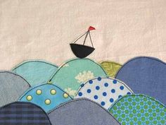 a patchwork quilt with a sailboat on it