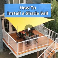 a deck with a yellow awning over it and two people sitting at the table