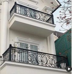 a balcony with wrought iron railing and balconies on the side of a house