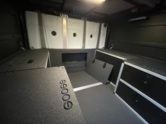 an empty kitchen with black cabinets and white appliances on the counter top, in a dark room