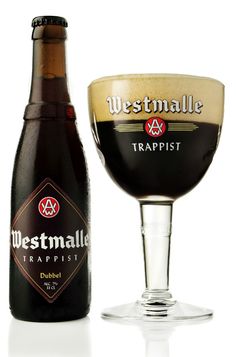 a bottle of westmale trappist next to a glass filled with beer