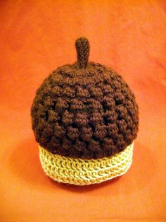 a crocheted cupcake sits on an orange surface