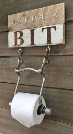 a toilet paper holder hanging on the side of a wooden wall with a sign that says, just use a bit