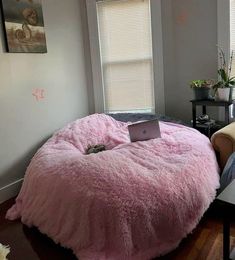 a pink bean bag chair with a laptop on it