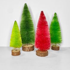 three different colored trees on wooden stumps