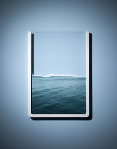 an open window with the ocean in front of it and blue sky behind it, as seen from below