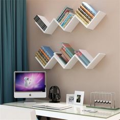 a desk with a computer and bookshelves on the wall in front of it