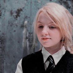 a girl with blonde hair wearing a vest and tie