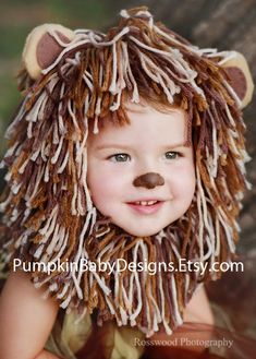 a young child wearing a lion costume with long hair and a fake animal's nose