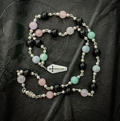 🌙 Welcome to Happy Little Crow's enchanting world! 🌙 🖤 Caw-caw! Greetings, kindred spirits! I'm your joyful companion, a little crow, here to unveil a treasure that bridges the realms of pastel dreams and gothic allure. Feast your eyes upon our handmade Pastel Goth Beaded Necklace! 🔮 Picture the dance of light on amethyst, the depth of obsidian, the softness of rose quartz, the serenity of mint quartz, and the tranquility of aquamarine. These exquisite gemstones come together in harmonious contrast, like a moonlit midnight sky and a cotton candy sunset. ⚰️ And now, the pièce de résistance - a delicate white enamel coffin charm adorned with a haunting black cross. It's a symbol of the delicate balance between the ethereal and the dark, a tribute to the beauty found in both realms. 🌌 Ou Jewelry Alternative, Caw Caw, Kiss Day, Midnight Sky, Kindred Spirits, Quartz Rose, Gothic Jewelry, Pastel Goth, White Enamel