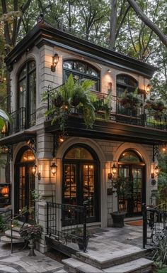 a house with lots of windows and plants on the balconies, surrounded by trees