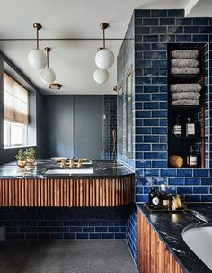 a bathroom with two sinks and blue brick walls