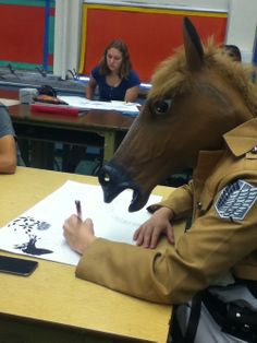 a person in a horse mask writing on a piece of paper