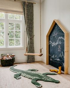 a child's room with a chalkboard in the corner and an alligator rug on the floor