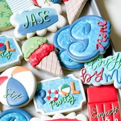 decorated cookies in the shape of beach scenes are displayed on a tray with writing and numbers