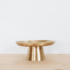 a gold plate sitting on top of a wooden table