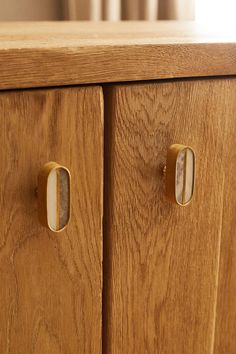 a wooden cabinet with brass handles and knobs