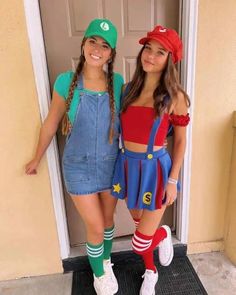 two girls dressed up as super mario and luigi in front of a door with their arms around each other