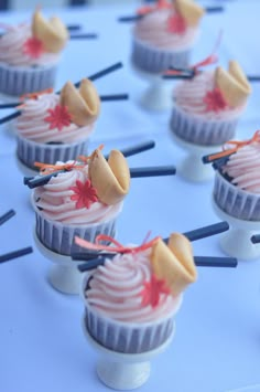 small cupcakes with candy toppings on them sitting on a blue tablecloth