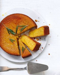 a white plate topped with cake next to a knife and fork