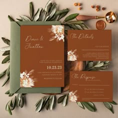 the wedding stationery is laid out on top of each other with flowers and leaves