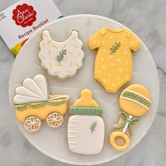 some cookies are sitting on a plate with baby's clothes and other items in it