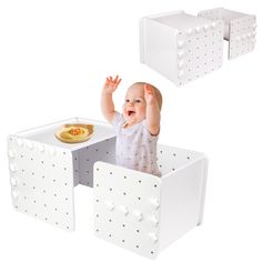 a baby sitting in a white chair with two trays on the back and one holding his hands up