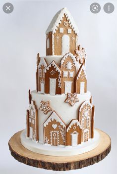 a three tiered gingerbread decorated cake on top of a wooden slice with white frosting