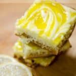 three pieces of cake sitting on top of a cutting board next to a slice of lemon