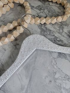 a necklace with wooden beads is laying on a marble surface next to a large beaded snake