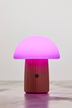 a mushroom shaped light sitting on top of a wooden table next to a white wall