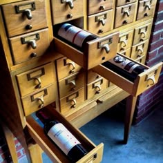 a wine bottle is sitting in a drawer next to a wooden cabinet with many drawers