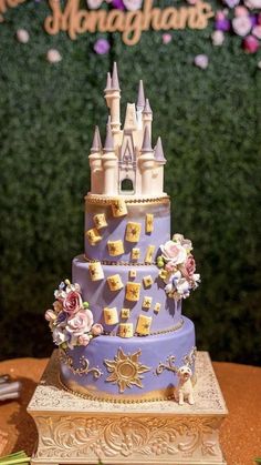 a purple and gold cake with a castle on top