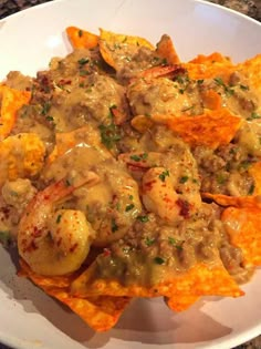 a white plate topped with nachos and shrimp