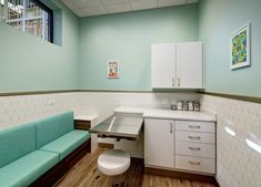 a room with a couch, sink and cabinets in it at the end of the hallway