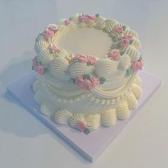 a cake with white frosting and pink flowers on it