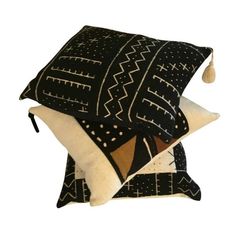 two black and white pillows with tassels on them