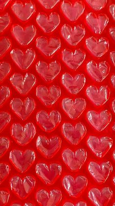 many red hearts are arranged in the shape of heart shapes on a bright red background