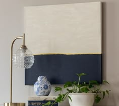 a blue and white vase sitting on top of a table next to a book shelf