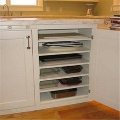 an open cabinet in a kitchen filled with dishes