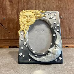 a ceramic sun and moon frame sitting on top of a table