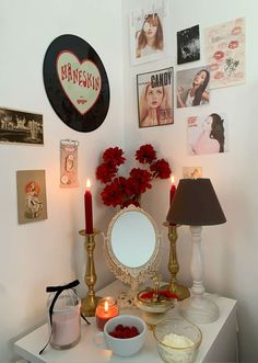 a white table topped with red roses next to a mirror and candlelight candles on top of it