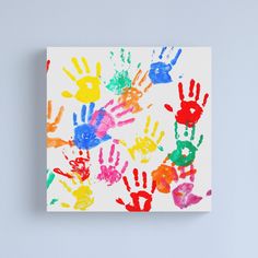 colorful hand prints on white canvas mounted on wall