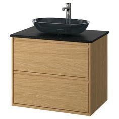 a bathroom sink with a black bowl on it's top and wooden cabinet doors