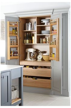 an open cabinet in a kitchen filled with appliances