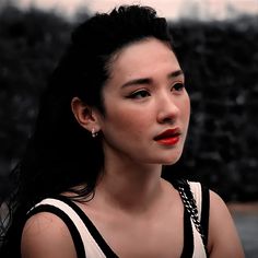 a woman with black hair and red lipstick