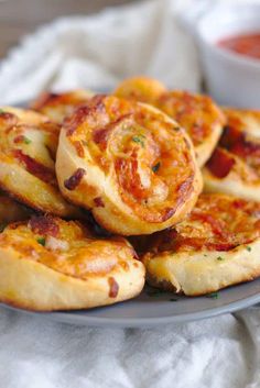 small pizzas on a plate with sauce and parsley in the bowl behind them