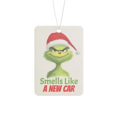 an ornament with the grin face and santa's hat on it that says smells like a new car