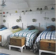 two beds in a room with white walls and blue rugs on the floor next to each other