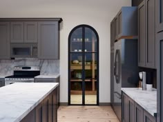 a kitchen with an arched glass door and marble counter tops